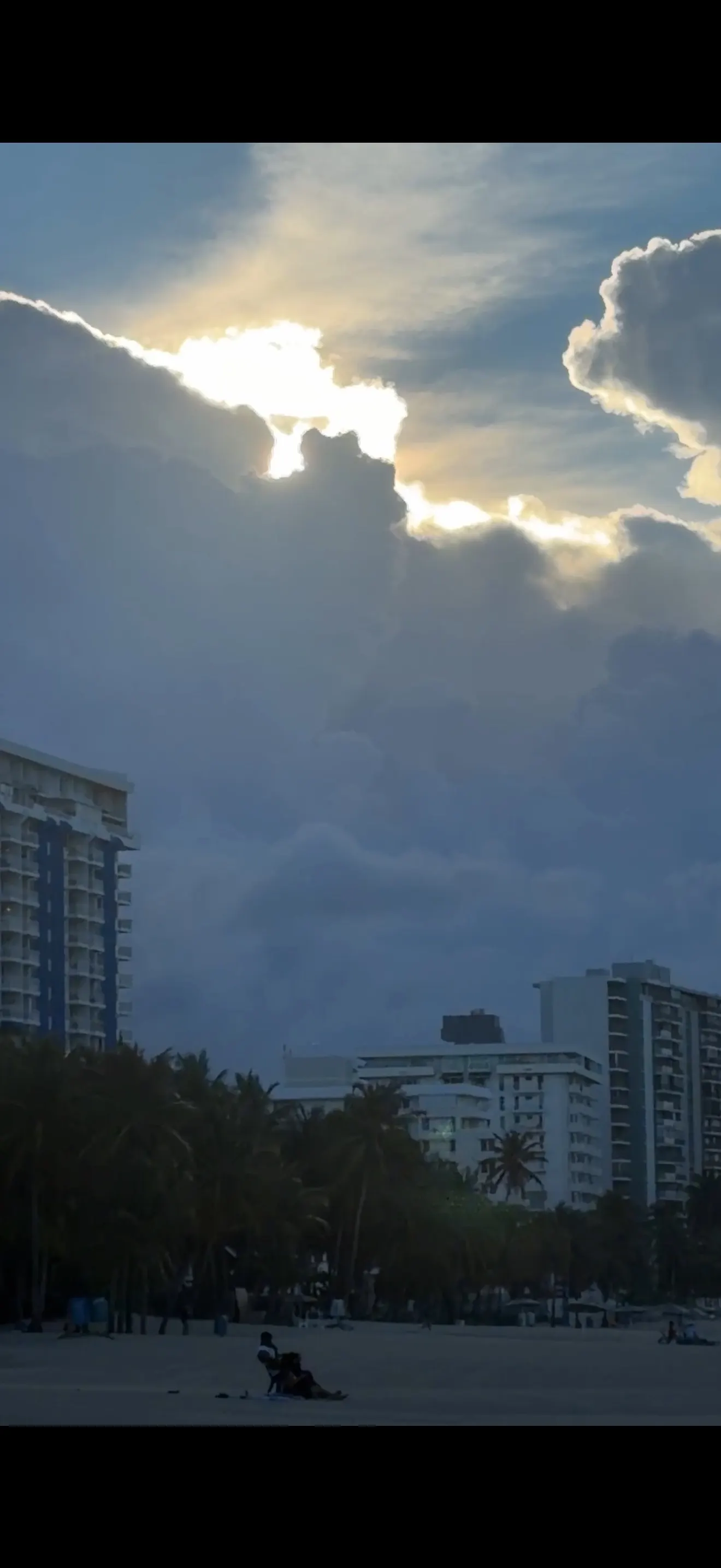 Sunlit clouds above the Isla Verde shoreline